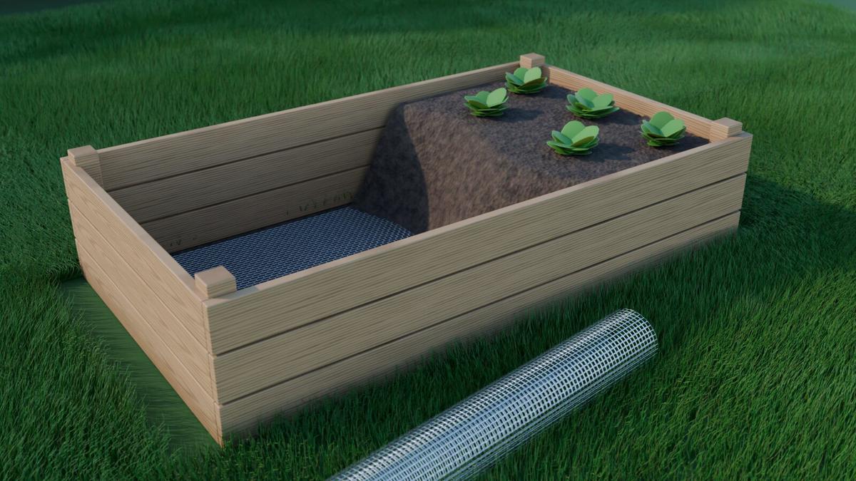 Potager surélevé en bois doublé de treillis inox, à moitié rempli de terre, avec un rouleau de grillage à côté